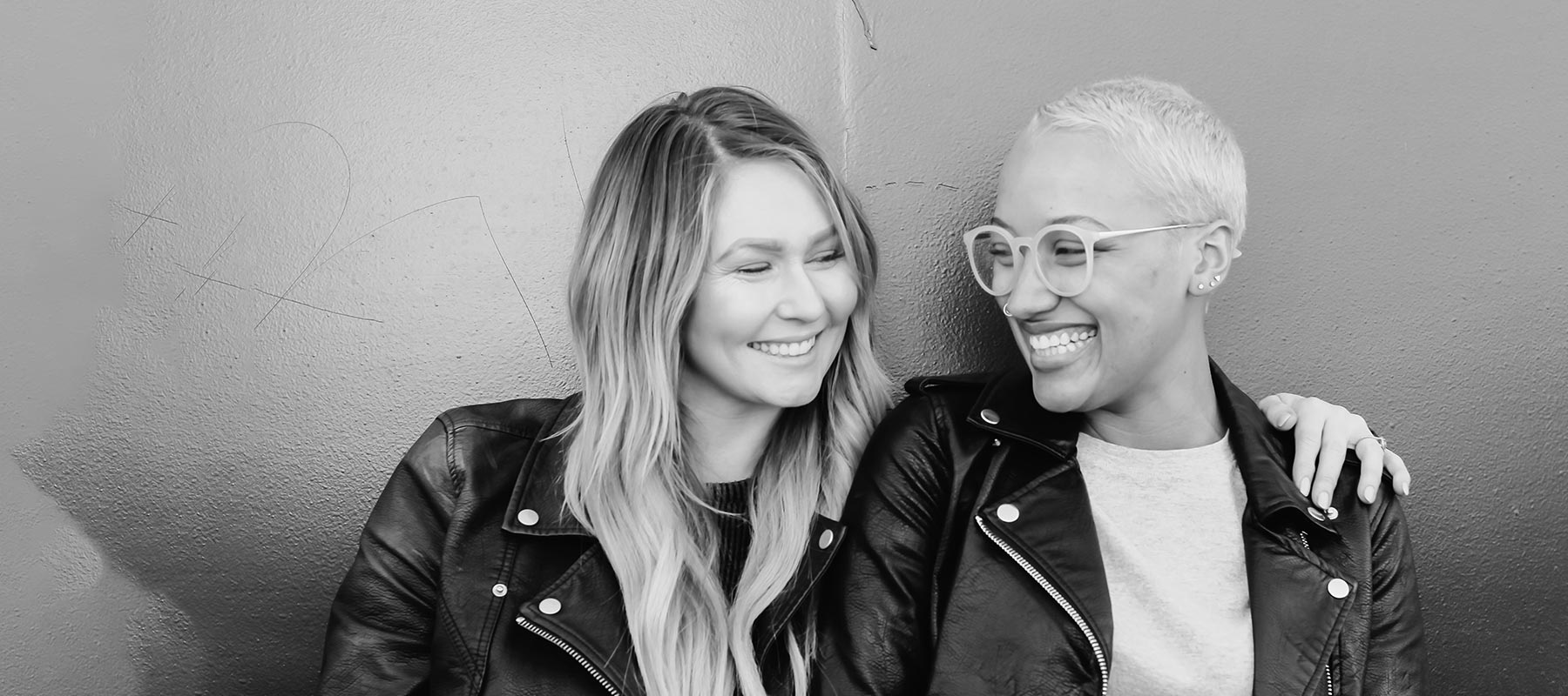 two young women smiling at one another
