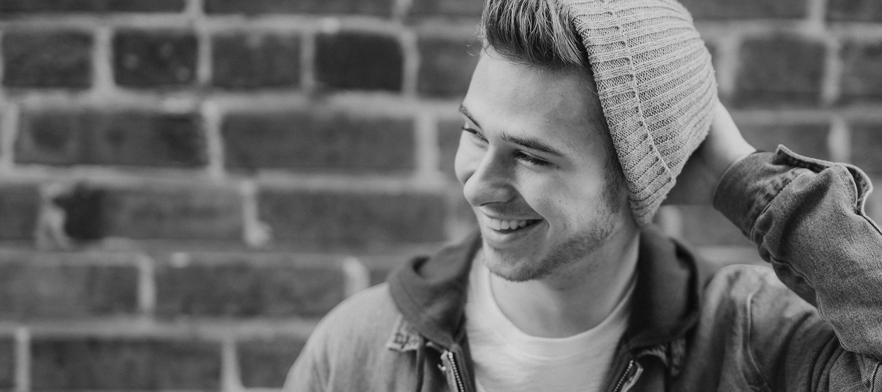 image of young man with beanie hat smiling